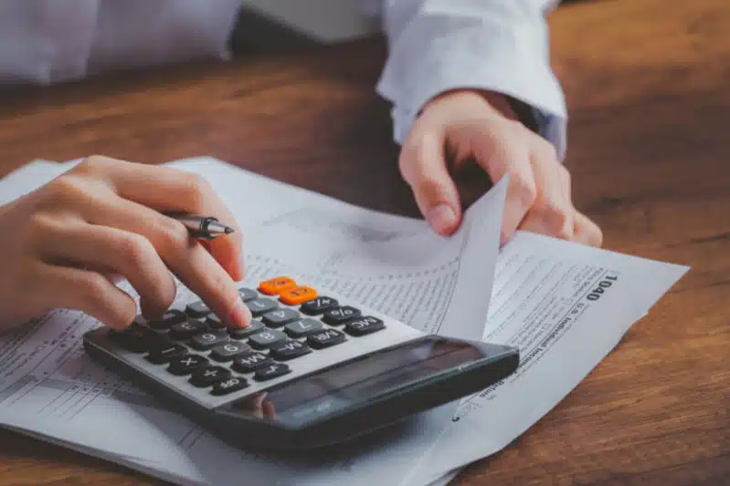 Iemand gebruikt een calculator om zijn betalingen bij te houden